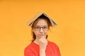 A pensive girl with glasses holds an open book on her head Royalty Free Stock Photo