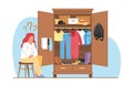 Pensive girl sits in front of closet with full of clothes and doesnt know what to wear. Thoughtful woman choosing outfit