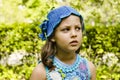 Pensive girl 8-9 years old in knitted blue hat.