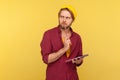 Pensive guy in hipster beanie hat standing thoughtful, pondering idea to write into notebook, taking notes in paper Royalty Free Stock Photo