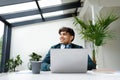 Pensive guy looking away while working on laptop, dreamy male freelancer thinking on ideas, sitting in coworking space Royalty Free Stock Photo