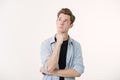 Pensive handsome young man wearing blue shirt over white background