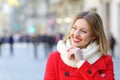 Pensive happy woman looking at side in winter in the street