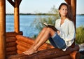 Pensive lady with book in summerhouse