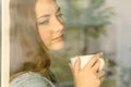 Pensive lady looking through a window