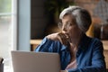 Pensive lady retiree study computer ponder on next step Royalty Free Stock Photo