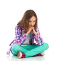 Pensive little girl sitting with legs crossed Royalty Free Stock Photo