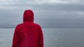 Pensive lonely man standing in the rain on the beach and gazing Royalty Free Stock Photo