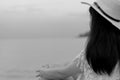 Pensive lonely young Asian woman. Side view of woman with sad feeling in black and white scene sit by the sea. Depressed and stres Royalty Free Stock Photo