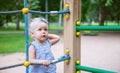 Pensive look of a child in front of a rope net on a playground