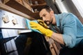 Pensive male cleaner polishing surface