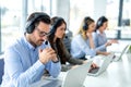 Pensive male operator listening to customer over headset and thinking about appropriate solutions for client issues. Royalty Free Stock Photo