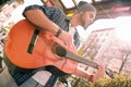 Pensive male guitarist refining skills on street