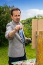 Pensive male painter panting his masterpiece in the open air Royalty Free Stock Photo