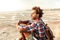 Pensive man with backpack sitting and drinking from hip flask Royalty Free Stock Photo