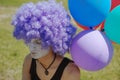 Pensive man in the clown costume next to the balloons