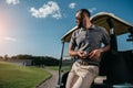 pensive man with golf ball in hand looking away while standing Royalty Free Stock Photo