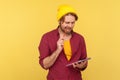 Pensive man in hipster beanie hat standing thoughtful biting pencil, pondering idea to write into notebook Royalty Free Stock Photo