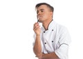 Pensive man holding pen. Cook wearing work uniform. Royalty Free Stock Photo