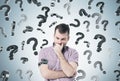 Pensive man and question marks Royalty Free Stock Photo