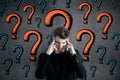 Pensive man with question marks Royalty Free Stock Photo