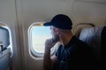 A pensive man sits at the window on an airplane Royalty Free Stock Photo