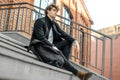 Pensive man sitting on concrete steps of modern red bricked building. Royalty Free Stock Photo