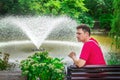 Pensive man, sitting on a wooden bench