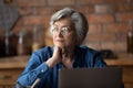 Pensive mature 60s woman look in distance thinking Royalty Free Stock Photo