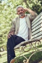 Pensive mature man sitting on bench in an urban park. Royalty Free Stock Photo