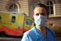 Pensive medical doctor woman with stethoscope and medical mask