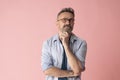 portrait of pensive mature man in glasses. Happy handsome bearded man in spectacles holding his hand on his chin Royalty Free Stock Photo