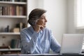 Pensive middle aged woman distracted from computer work. Royalty Free Stock Photo