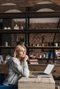 pensive middle aged woman holding credit card and looking away while using laptop with website Royalty Free Stock Photo