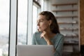 Pensive female employee work on laptop thinking Royalty Free Stock Photo