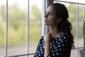 Pensive millennial woman looking out of window. Royalty Free Stock Photo