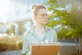 pensive modern business woman in green blouse and eyeglasses Royalty Free Stock Photo