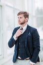 Pensive newcomer businessman in a business suit stands near the Royalty Free Stock Photo