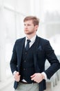 Pensive newcomer businessman in a business suit stands near a wi Royalty Free Stock Photo