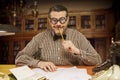 Pensive office employee with a pencil in his mouth looking up