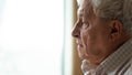 Pensive older man looking out of window, recollecting memories. Royalty Free Stock Photo