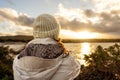 Pensive person view from back looking at the horizon. Unrecognizable woman seen from behind dressed in winter wool hooded clothes Royalty Free Stock Photo