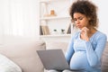 Pensive pregnant woman using laptop at home Royalty Free Stock Photo