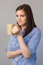Pensive pretty brunette holding cup of coffee Royalty Free Stock Photo