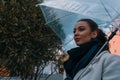 Pretty girl holding umbrella and strolling on rainy autumn day. photo looks like film frame or movie screenshot. Royalty Free Stock Photo