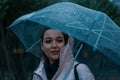 Pretty girl holding umbrella and strolling on rainy autumn day. photo looks like film frame or movie screenshot Royalty Free Stock Photo