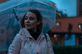 Pretty girl holding umbrella and strolling on rainy autumn day. photo looks like film frame or movie screenshot Royalty Free Stock Photo