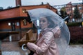 Pensive girl holding umbrella while strolling on rainy autumn day. photo looks like film frame or movie screenshot. Royalty Free Stock Photo