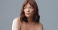 Pensive pretty naked woman isolated on gray background. Mature beautiful looking at side on copy space. Spa and wellness