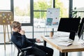 Pensive programmer looking at computers near